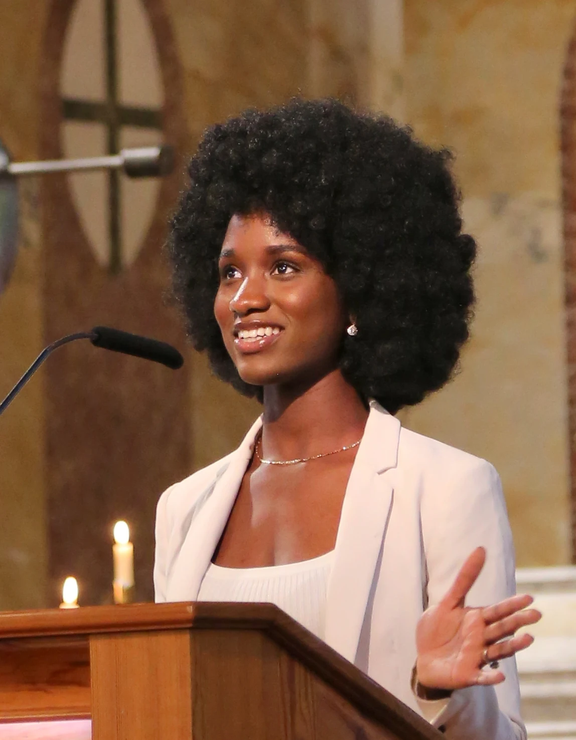 Elizabeth Zion speaking at a church lectern in a light blazer