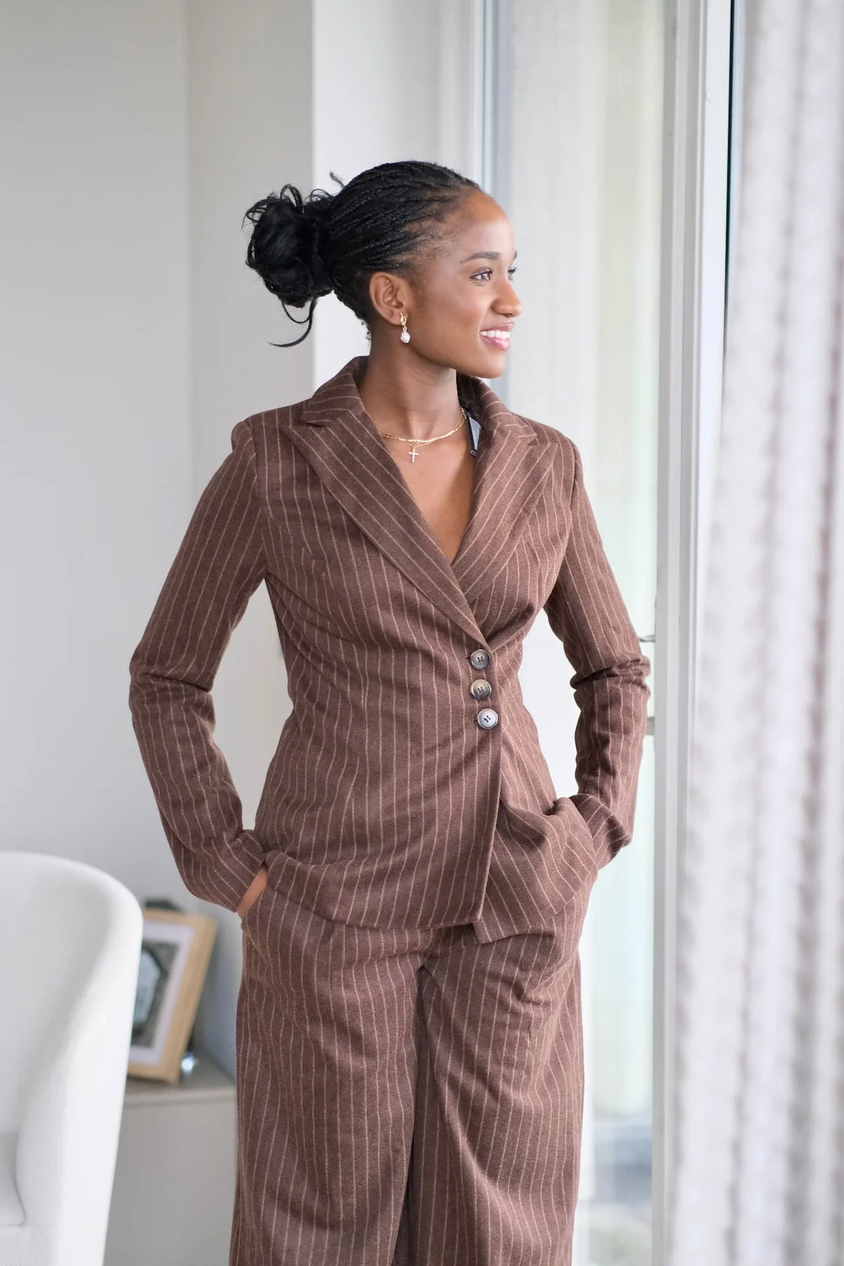 Elizabeth Zion in a brown pinstripe suit, smiling at the camera
